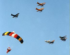 Jim Wine brings in the US flag at the Flying Circus Airshow, while the formation of show planes pass overhead.  (photo courtesy - Vernon Poole)